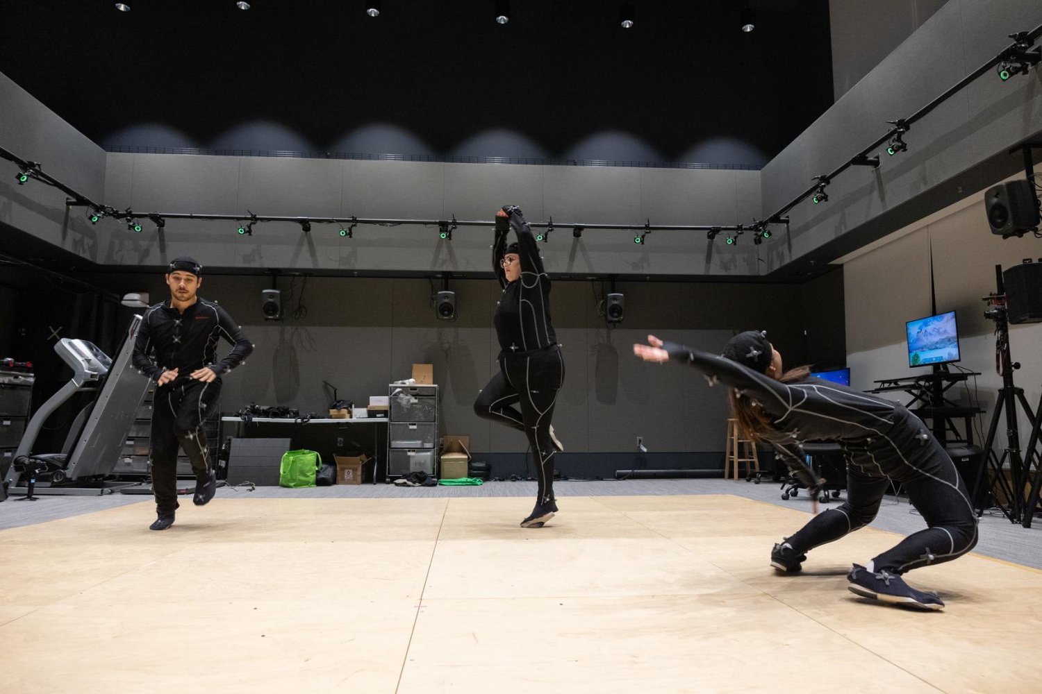Emerson College students wear full body suits paired to the OptiTrack motion-capture system in the MIT.nano Immersion Lab to generate virtual characters.