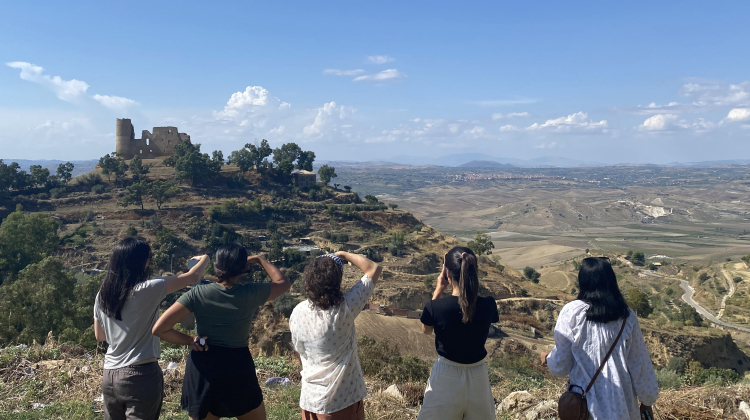 Students take a photo of a mountain village in Italy