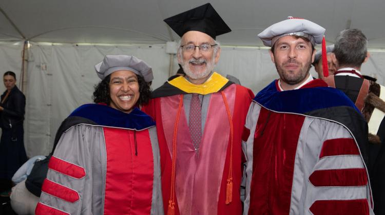 Faculty member poses with two PHD graduates at reception