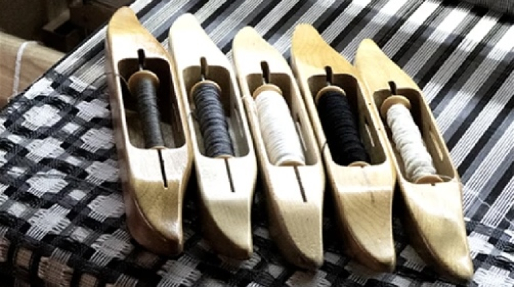 Five weaving tools on a loom