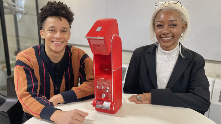 man and woman sit at table with device they created