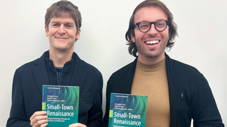 two men holding books they authored