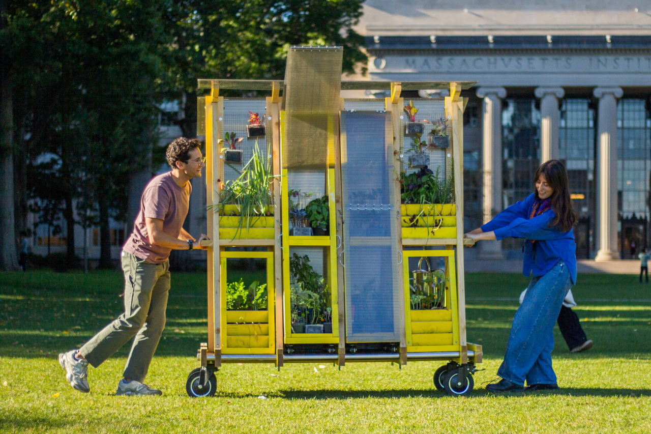 Zachary Rapaport (left) and Aleks Banaś move their farm cart across the MIT campus. The two graduate architecture students co-designed and built the cart.