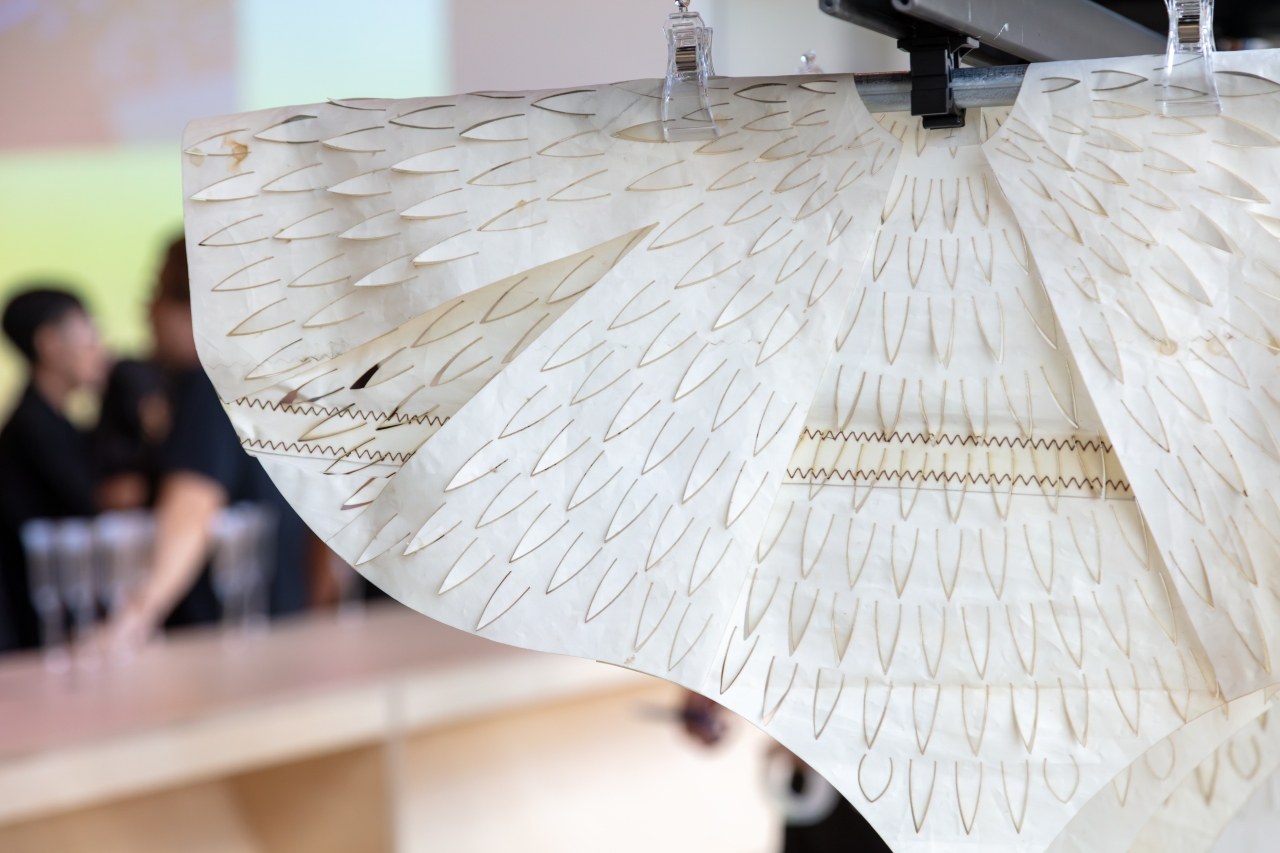 Recycled sail white canvas with cuts in the shape of pointed feathers. 