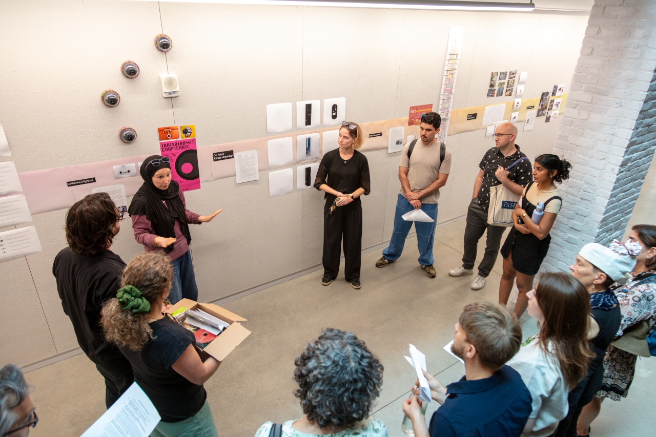 Group of people gathered in a circle in the MIT Metropolitan Storage Warehouse corridor
