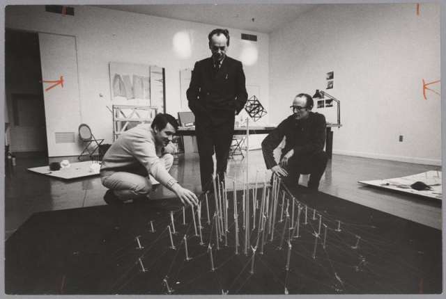 Photo of György Kepes with Harold Tovish and Otto Piene with sculpture in a studio.
