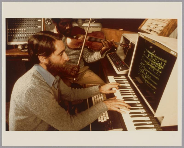 Photo of individuals playing instruments connected to a computer in the Media Lab.