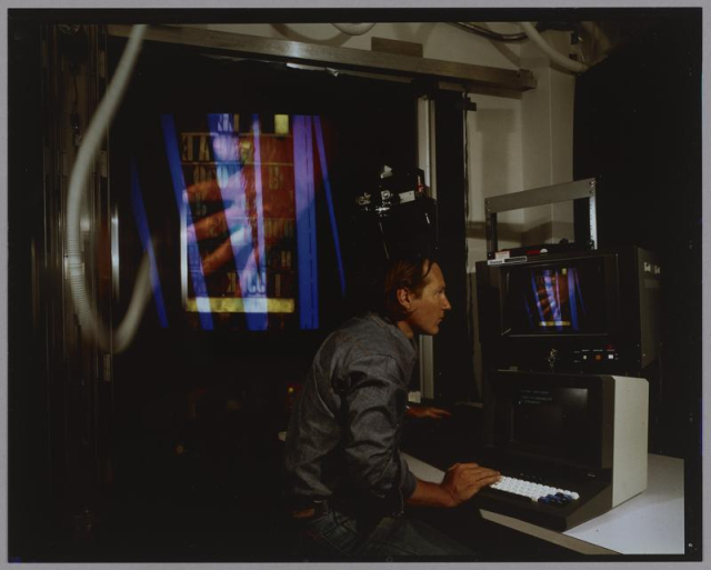 Photo of a student at a computer monitor within the MIT Media Lab.