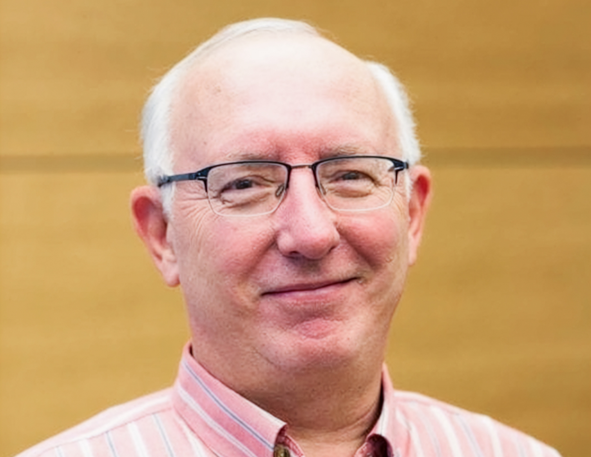 Headshot of Walter Torous, wearing glasses and a pink striped shirt. 